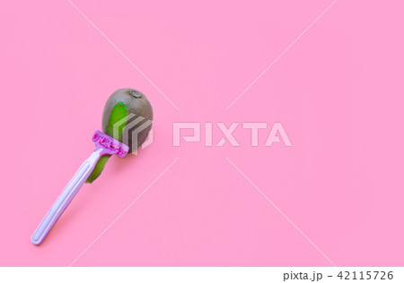 Kiwi fruit and razor on violet background. Hair removal concept. 42115726