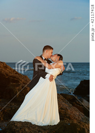 Bride and groom kissing on sunset light Bride and groom kissing on sunset light 42117418