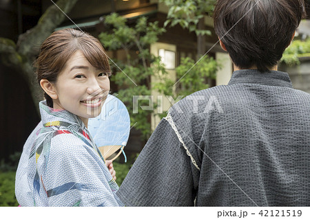 夏イメージ 浴衣と甚平で手を繋いで歩く男女 浴衣デートの写真素材