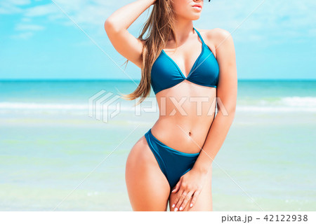 A young girl with long hair in swimsuit on beach  42122938