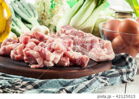 Raw pork belly pieces on a cutting board Raw pork belly pieces on a cutting board 42125015