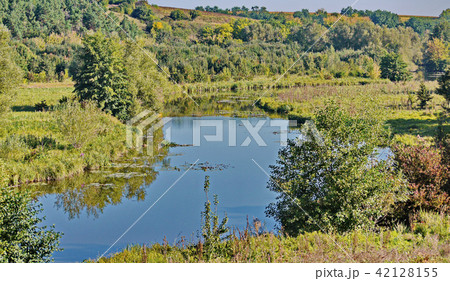 Landscape with a small blue river and greenery on  42128155