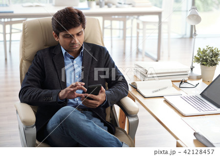 Businessman answering text messages Businessman answering text messages 42128457