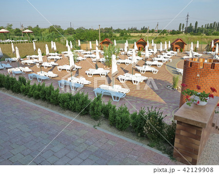 Beach area with white sun loungers, umbrellas and  42129908