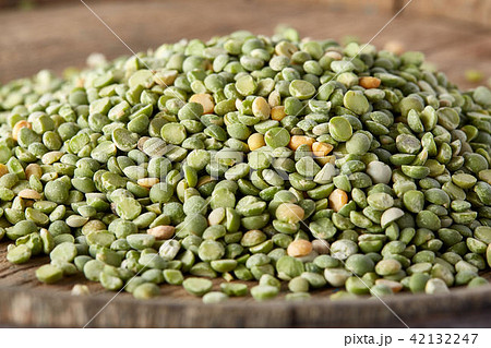 Pile of green peas on the top of wooden barrel, close-up, top view, selective focus. 42132247