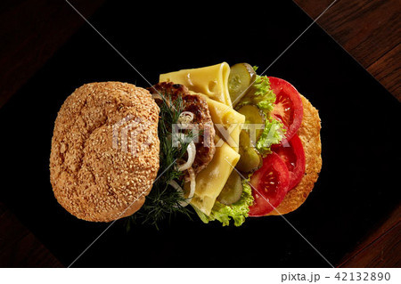 Big fresh burger on black plate on wooden background. Big fresh burger on black plate on wooden background. 42132890