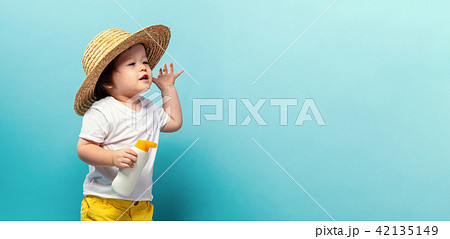 Toddler boy with a bottle of sunblock 42135149
