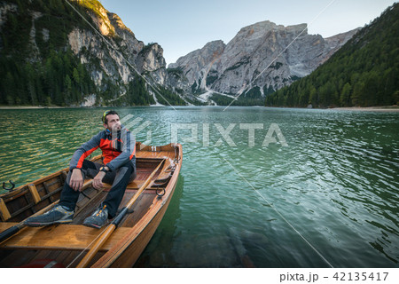 man seating on boat on lago di braies, italien dol man seating on boat on lago di braies, italien dol 42135417
