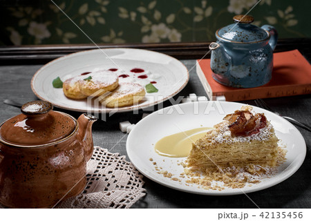 Various desserts, cheese cakes dessert, napoleon cakes, kettle with tea 42135456