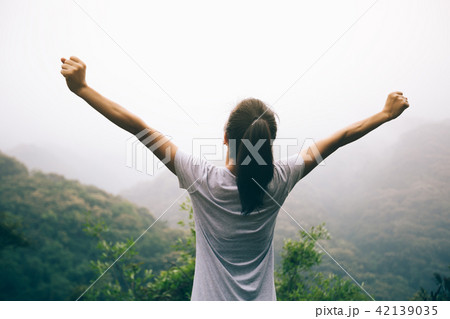 Happy woman outstretched arms on mountain valley Happy woman outstretched arms on mountain valley 42139035