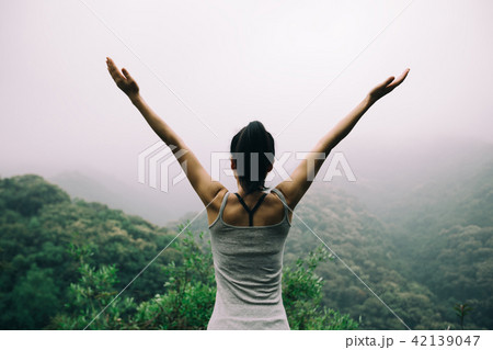 Happy woman  outstretched arms on  mountain valley 42139047