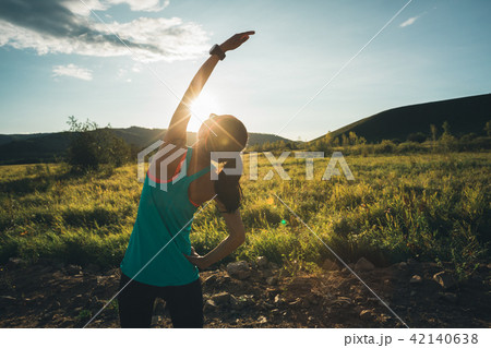 woman stretching arms before run on sunset   42140638