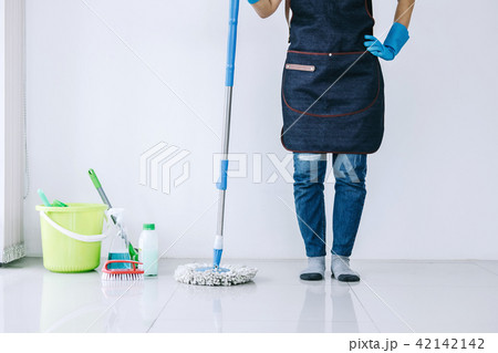 Housekeeping and cleaning concept, Happy young woman in blue rub Housekeeping and cleaning concept, Happy young woman in blue rub 42142142