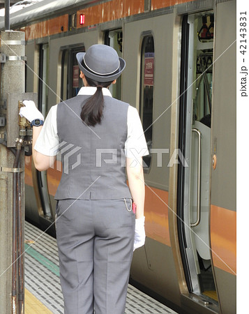 朝ラッシュが終わり一息ついても気を抜くことはない女性車掌さんの後ろ姿の写真素材