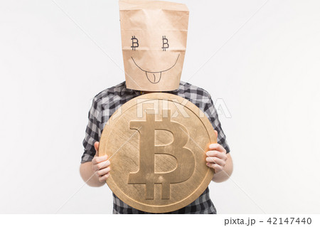 Men in happy paper bag mask with bitcoin on his hands 42147440