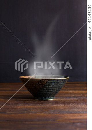 Ceramic bowl with smoke on wooden table. Ceramic bowl with smoke on wooden table. 42148150