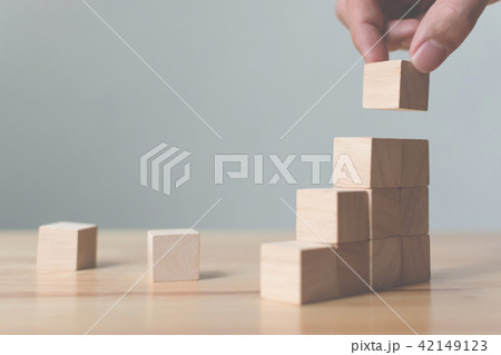 Hand arranging wood block stacking as step stai 42149123