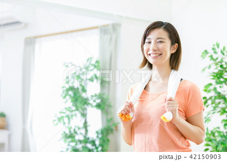 汗を拭く女性　スポーツをする女性　エクササイズ　休憩　水分補給　水を飲む　 42150903