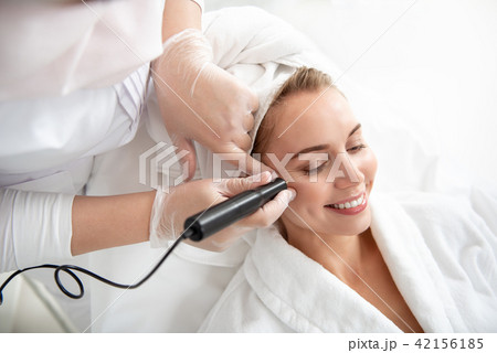 Cheerful lady during face cleaning Cheerful lady during face cleaning 42156185