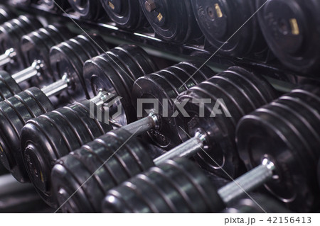 Black dumbbell set in sport fitness center. Weight Training Equipment concept. Black dumbbell set in sport fitness center. Weight Training Equipment concept. 42156413