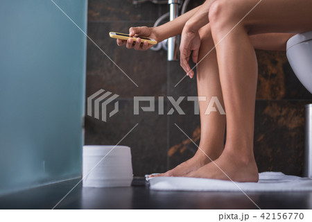 Woman using phone in lavatory 42156770