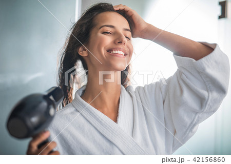 Happy girl using appliance for wet head Happy girl using appliance for wet head 42156860