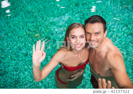 Smiling couple swimming in pool Smiling couple swimming in pool 42157322