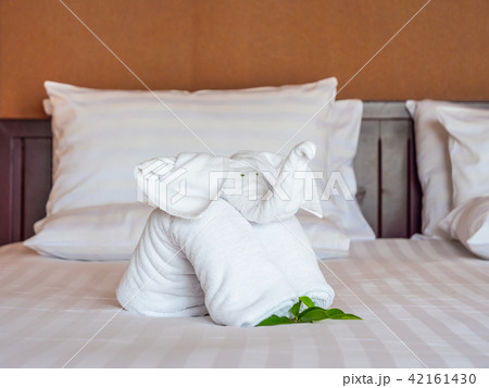 White elephant towel and comfortable pillow on bed White elephant towel and comfortable pillow on bed 42161430