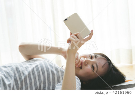 寝ながらスマホを触る女性 寝ながらスマホを触る女性 42161960