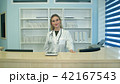 Smiling female doctor at the reception looking at the camera 42167543
