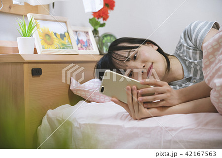 部屋でスマホを触る女性 42167563