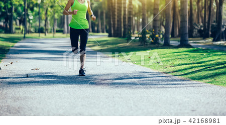 young fitness woman running at tropical park 42168981