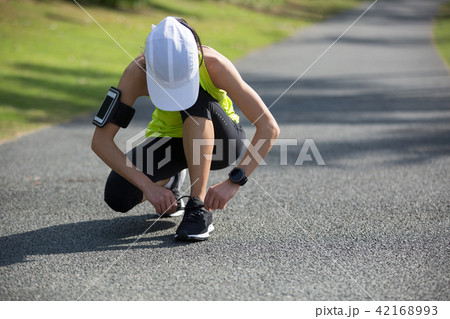 woman runner tying shoelace at tropical park 42168993