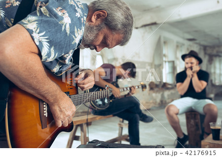 Repetition of rock music band. Electric guitar player and drummer behind the drum set. Repetition of rock music band. Electric guitar player and drummer behind the drum set. 42176915