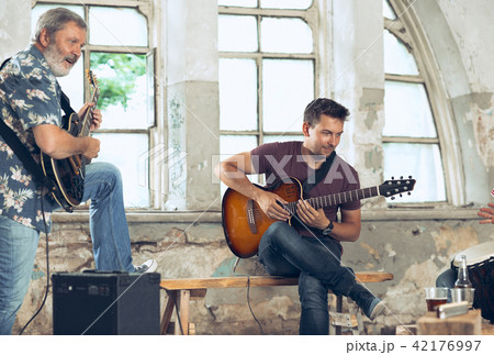 Repetition of rock music band. Electric guitar player and drummer behind the drum set. Repetition of rock music band. Electric guitar player and drummer behind the drum set. 42176997