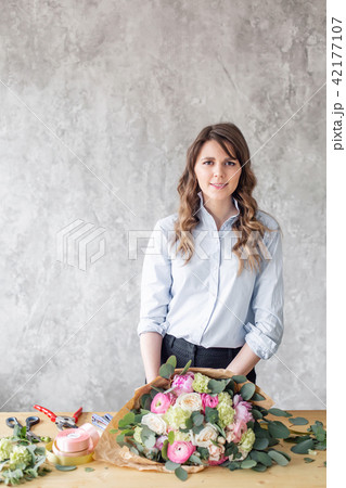 Young Woman looking at the camera, holds a luxurious bouquet in his hands. florist creating Young Woman looking at the camera, holds a luxurious bouquet in his hands. florist creating 42177107