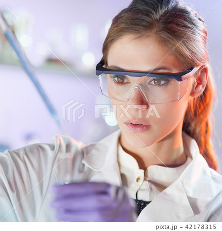 Young scientist pipetting in life science laboratory. 42178315