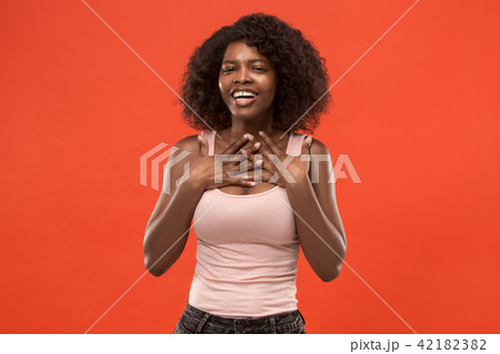 The happy african woman standing and smiling against red background. The happy african woman standing and smiling against red background. 42182382