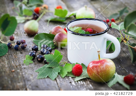 Enameled cup of fruit tea with fruits 42182729