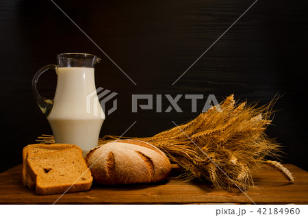 Wooden table with a jug of milk, rye bread Wooden table with a jug of milk, rye bread 42184960