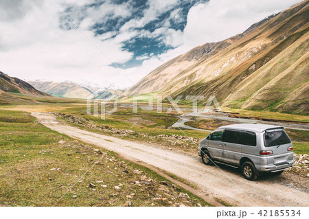 SUV Car On Off Road In Spring Mountains Landscape In Truso Gorge SUV Car On Off Road In Spring Mountains Landscape In Truso Gorge 42185534