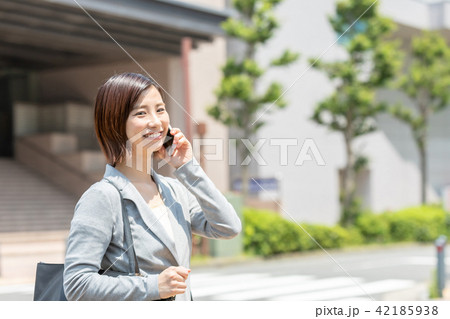 ビジネス街を歩く女性　オフィスレディ　出張中　新緑　OL　ビジネス　スーツ　ポートレート　リクルート 42185938
