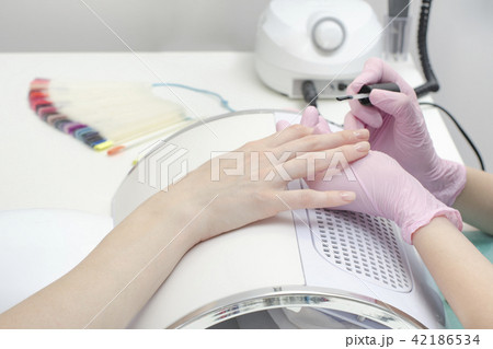 Hands in gloves paint nails in the salon Hands in gloves paint nails in the salon 42186534