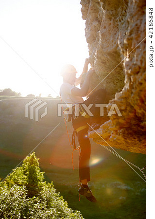 Image of rock climber in helmet climbing up mountain 42186848