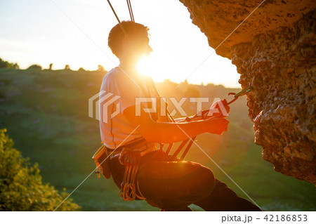 Picture of man clambering over rock. Picture of man clambering over rock. 42186853