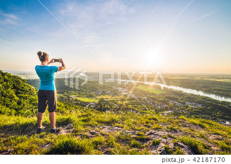 A Girl Taking Photograph of the Sunset A Girl Taking Photograph of the Sunset 42187170