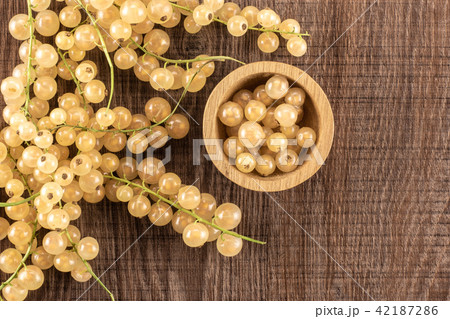 Fresh white currant berries on brown wood Fresh white currant berries on brown wood 42187286