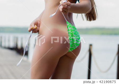 Sexy female adjusting bikini bottom 42190675