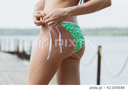Persoon belast met sportgame Cirkel Dezelfde Sexy female adjusting bikini bottom - Stock Photo [42190686] - PIXTA