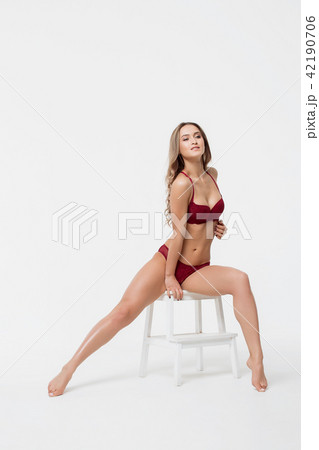Woman posing in underwear on chair in studio 42190706
